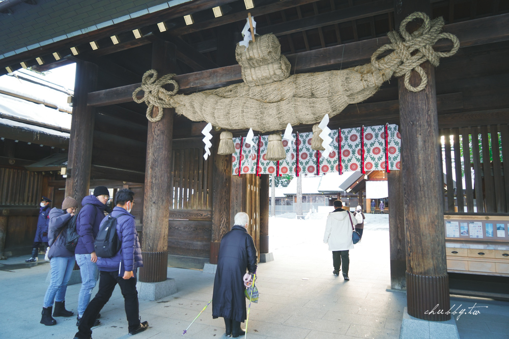 從掛有巨大注連繩的正門進入本殿，上頭的花紋是菊花，菊花正是日本皇室的象徵。